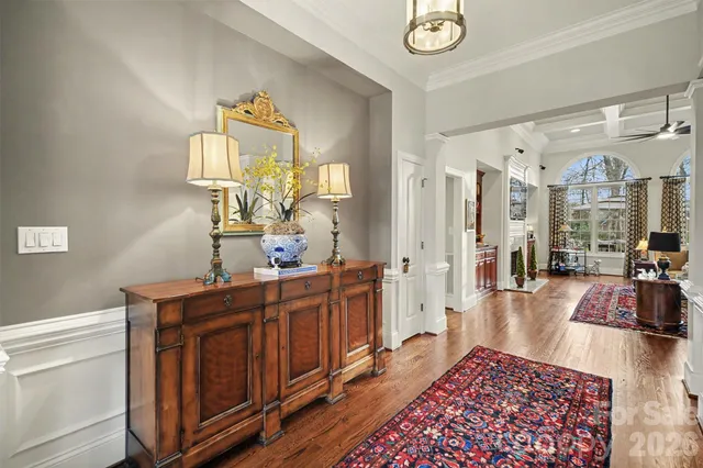 a living room with stainless steel appliances furniture a rug and a chandelier