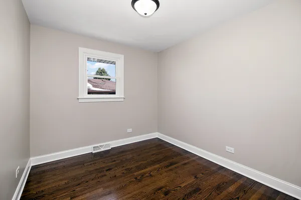 a view of a room with wooden floor and window