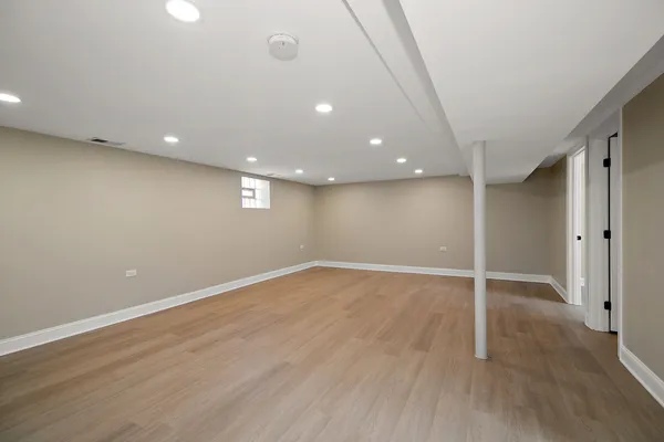 an empty room with wooden floor and door