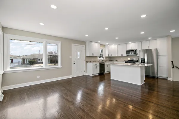 a view of kitchen with kitchen island wooden floor wooden floor and stainless steel appliances