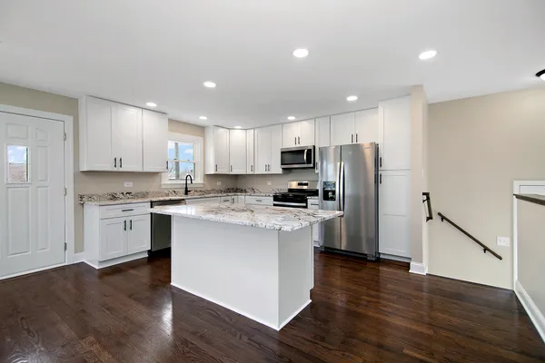 a kitchen with a refrigerator a sink and a stove top oven
