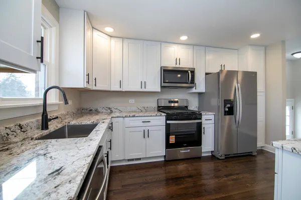 a kitchen with stainless steel appliances granite countertop a refrigerator sink and stove
