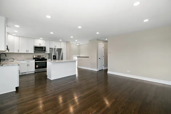 a view of kitchen with wooden floor and electronic appliances