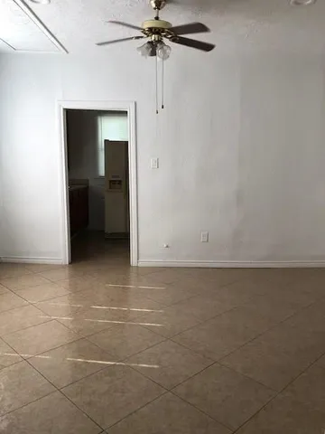 a view of a livingroom with wooden floor and a ceiling fan