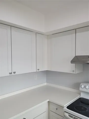 a kitchen with cabinets and a stove top oven