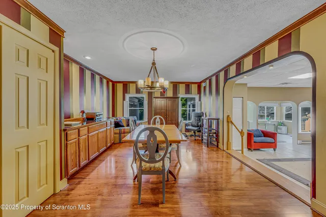 a view of a dining room with furniture a chandelier and wooden floor