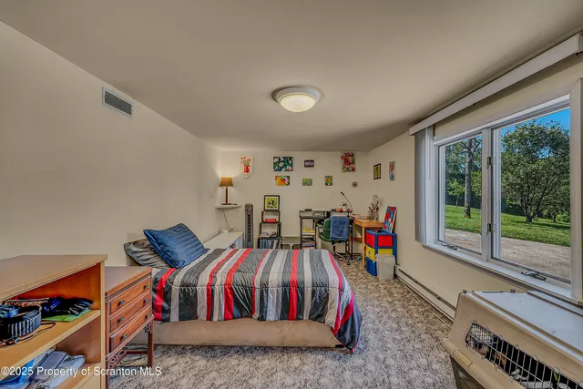a bedroom with furniture and a large window