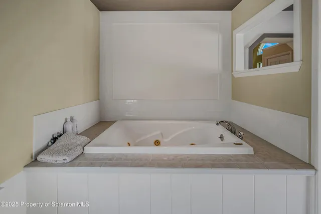 a bathroom with a granite countertop window and a bathtub