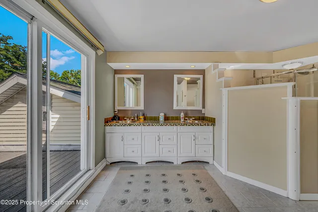 a bathroom with a granite countertop sink a mirror and shower