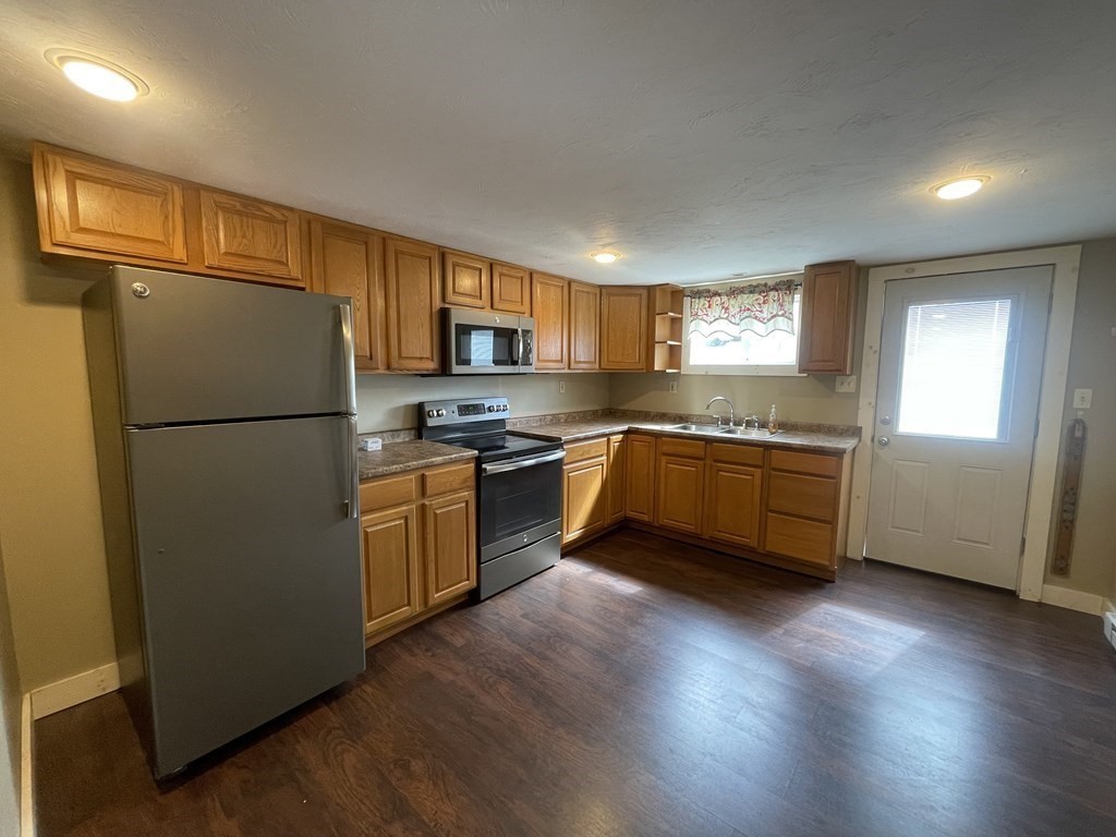 26 Wenonah Road Wareham, MA 02532 - Photo 6 of 21 a kitchen with a refrigerator a microwave a sink and cabinets