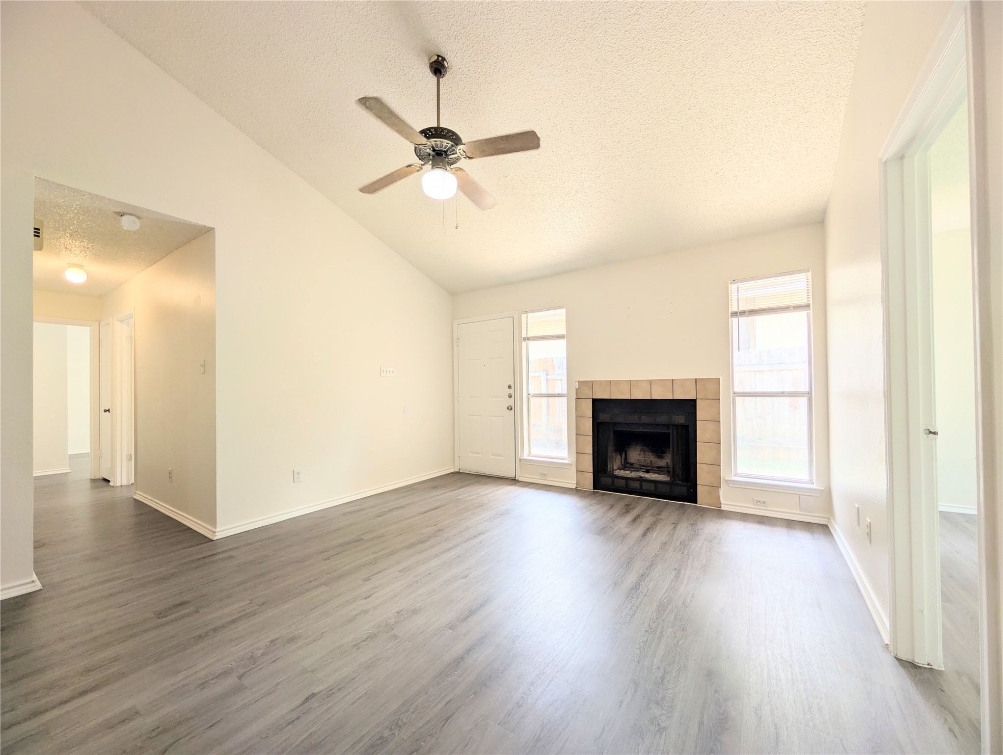 2036 Redwing Way Round Rock, TX 78664 - Photo 8 of 23 A welcoming living space features soaring vaulted ceilings and a cozy corner fireplace.