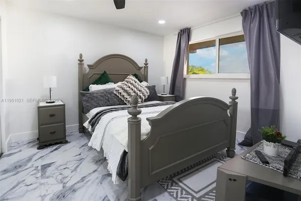 a bedroom with a bed and a flat screen tv