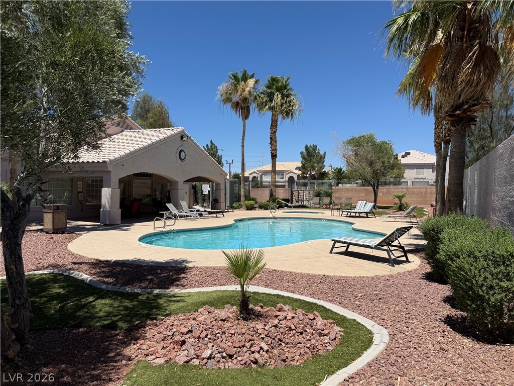 517 Crumpler Place Henderson, NV 89052 - Photo 3 of 9 An inviting community pool awaits, nestled amongst mature palm trees and desert-friendly landscaping.