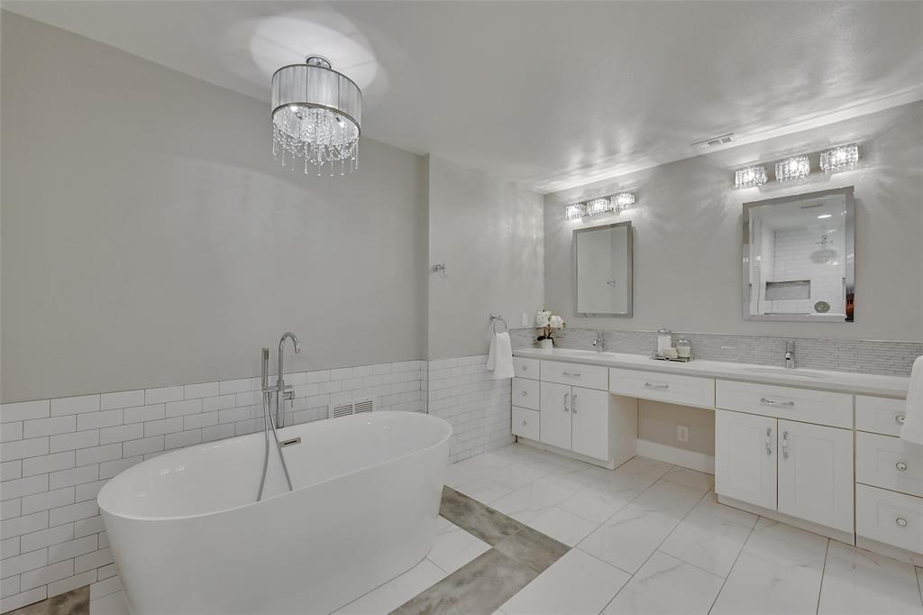 a large white bathroom with a large tub sink and vanity