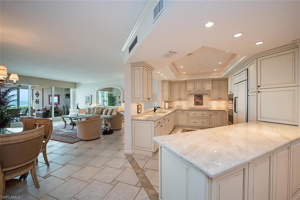 a large kitchen with kitchen island a living room filled with furniture and a couch