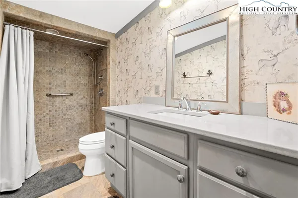 a bathroom with a sink a toilet and shower