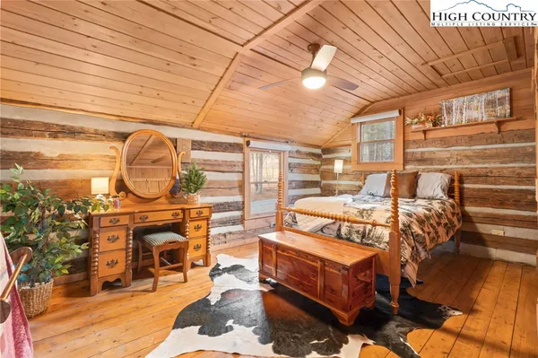 a spacious bedroom with a bed a mirror and a chandelier