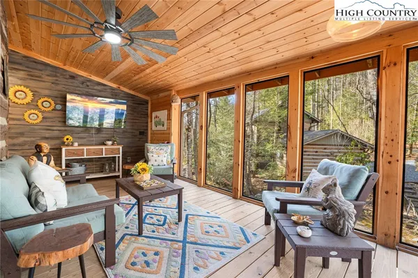 a living room with furniture ceiling fan and a large window