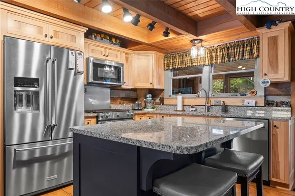 a kitchen with granite countertop a sink cabinets and stainless steel appliances
