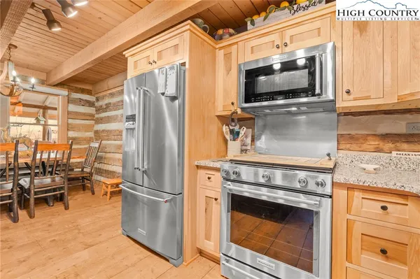 a kitchen with stainless steel appliances granite countertop a stove microwave and refrigerator