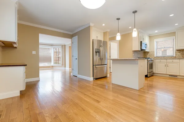 a view of a kitchen with wooden floor and a window