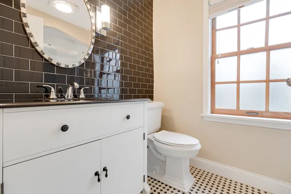 a bathroom with a sink a toilet and a mirror