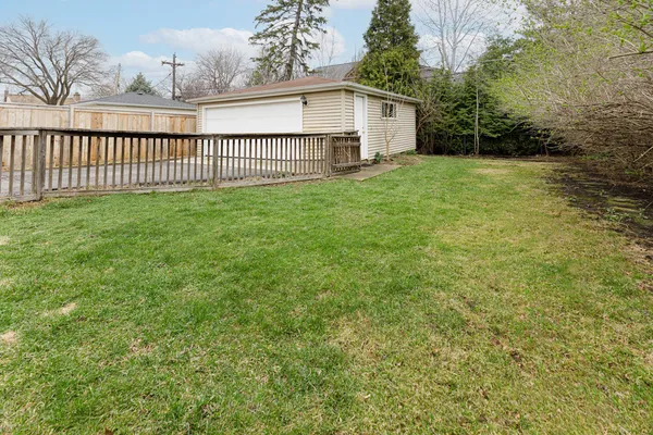 a view of a house with a yard and fence