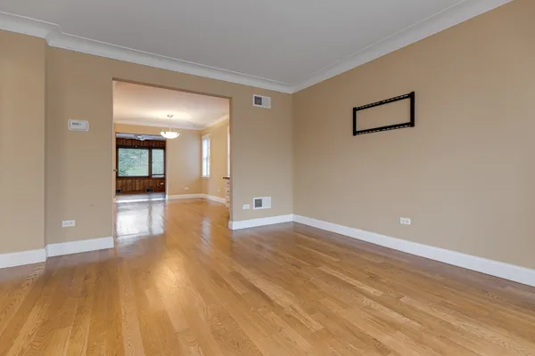 a view of a big room with wooden floor and windows