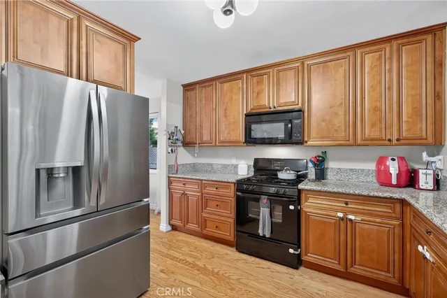 a kitchen with stainless steel appliances granite countertop a refrigerator stove and sink