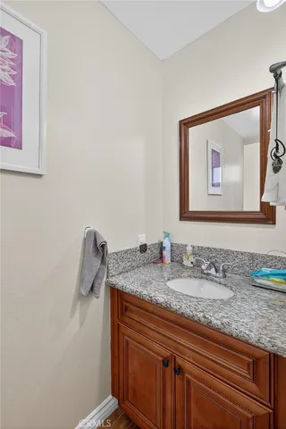 a bathroom with a granite countertop sink and a mirror