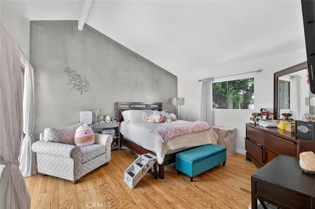 a bedroom with a bed and wooden floor