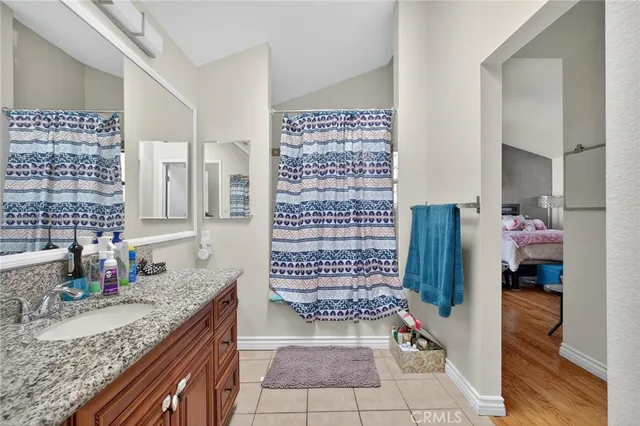 a bathroom with a granite countertop sink a mirror and shower