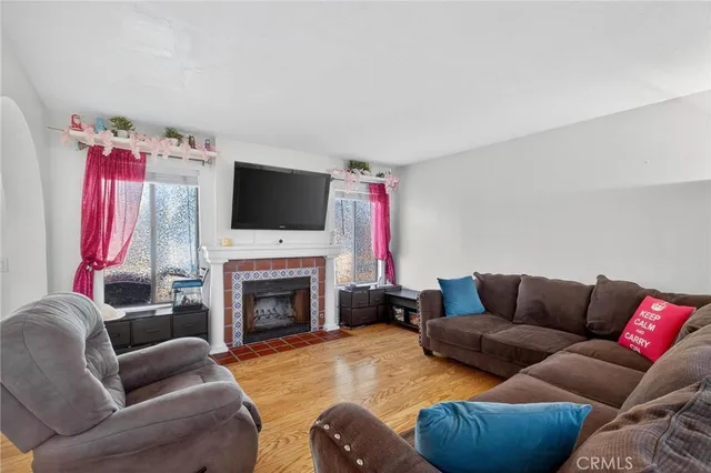 a living room with furniture a flat screen tv and a fireplace