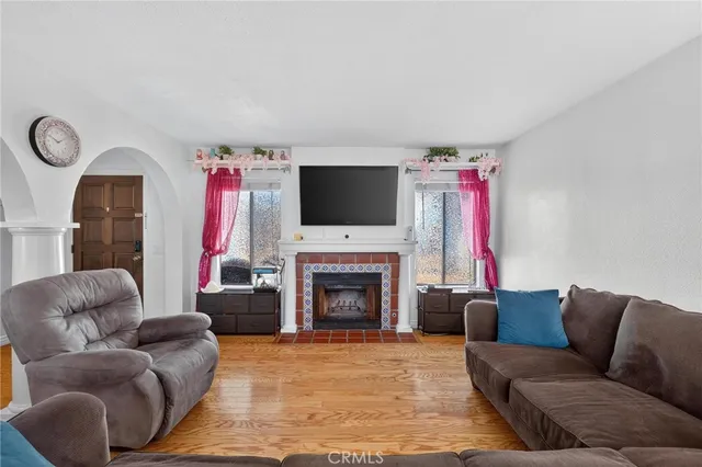 a living room with furniture a flat screen tv and a fireplace