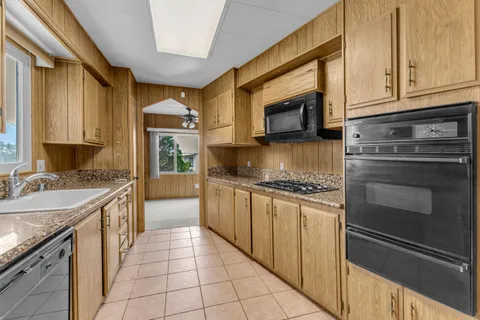 a kitchen with stainless steel appliances granite countertop a stove sink and cabinets