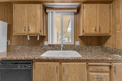a kitchen with granite countertop a sink and a refrigerator