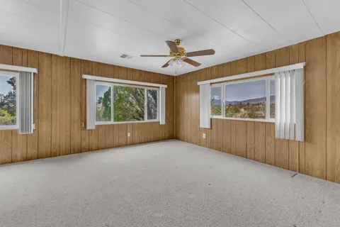 an empty room with windows ceiling fan and windows