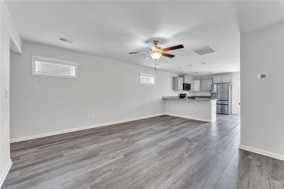 208 Samuel Street Pendleton, SC 29670 - Photo 6 of 32 An inviting open-concept layout features rich hardwood flooring and a functional kitchen bar.
