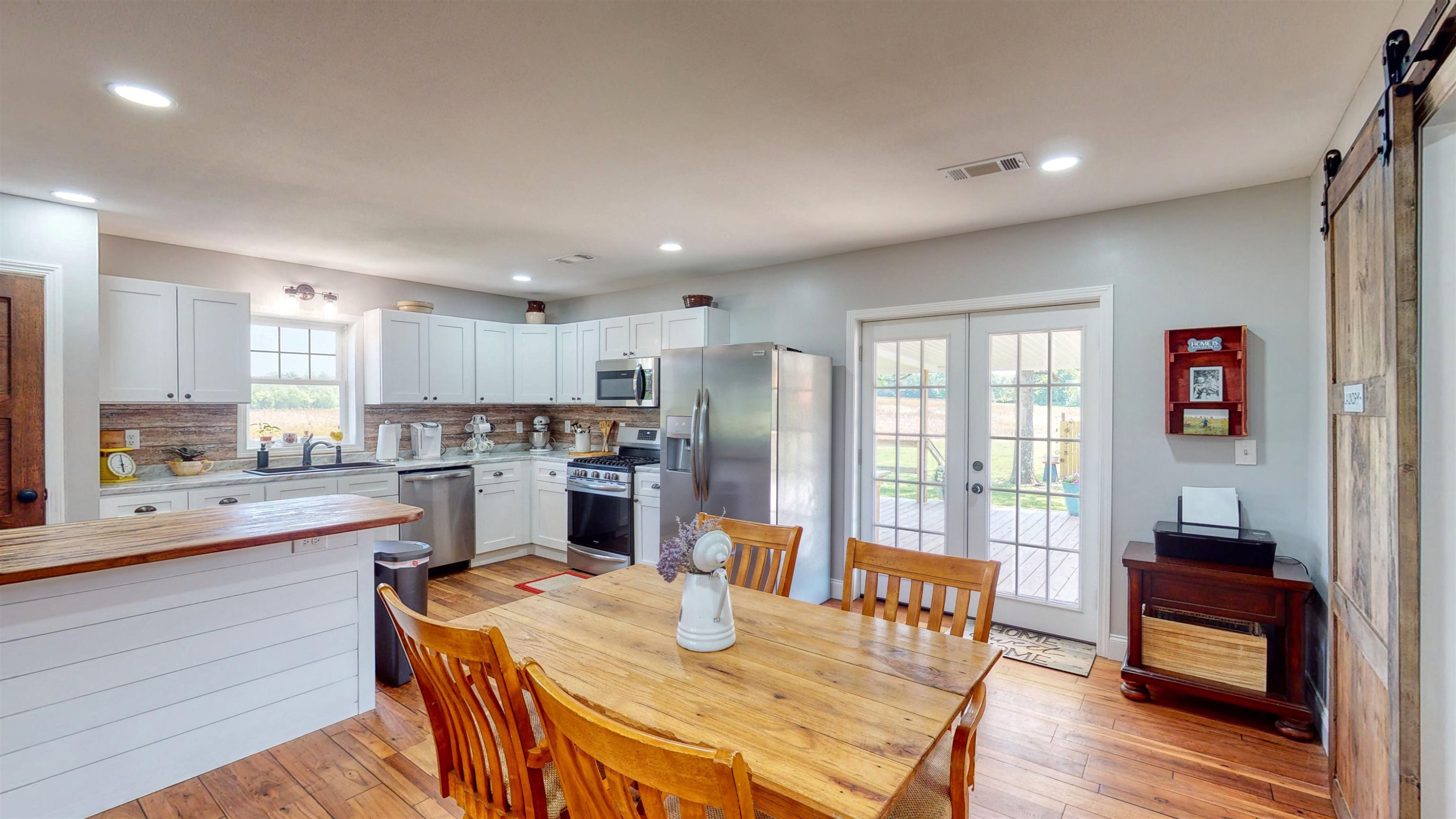 2694 East Grove Road Gleason, TN 38229 - Photo 7 of 30 a open kitchen with stainless steel appliances granite countertop a refrigerator a stove top oven a dining table and chairs with wooden floor