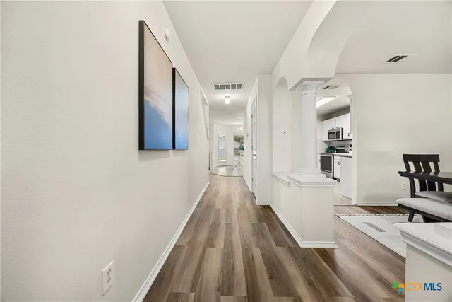 a view of a hallway with wooden floor and staircase