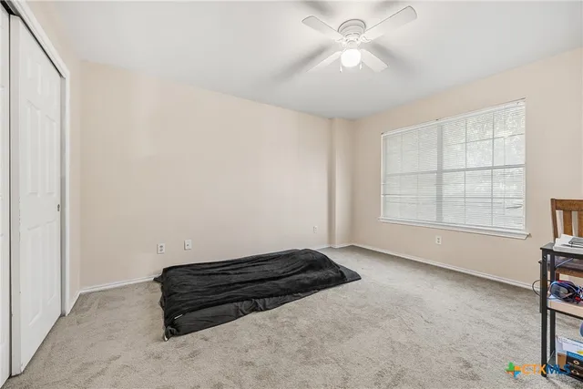 an empty room with windows and ceiling fan
