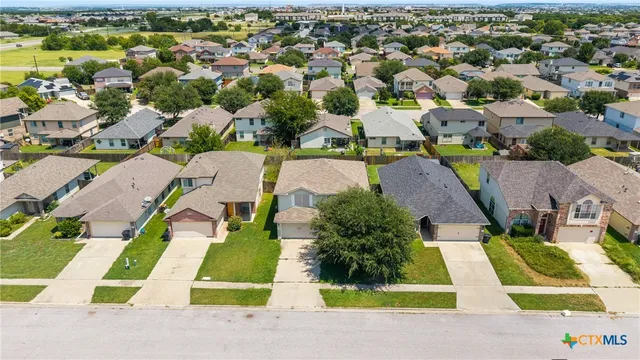 an aerial view of residential houses with yard and swimming pool