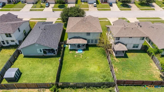 an aerial view of a house with swimming pool garden and patio