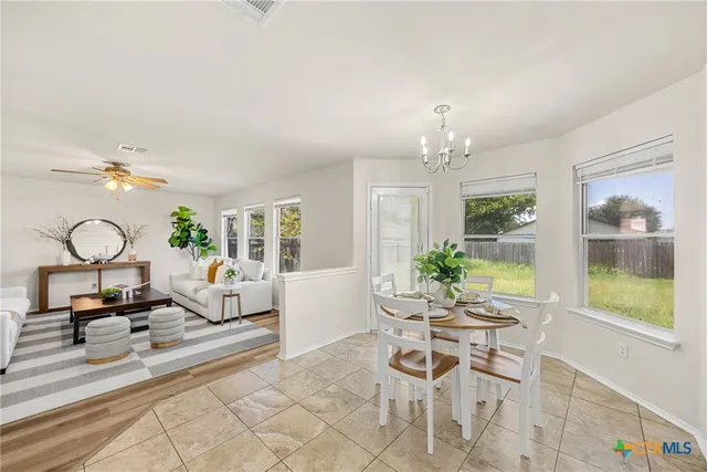 a living room with furniture a chandelier and a large window