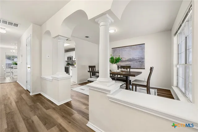 a kitchen with a dining table chairs and white appliances