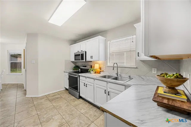 a kitchen with stainless steel appliances granite countertop a sink and cabinets