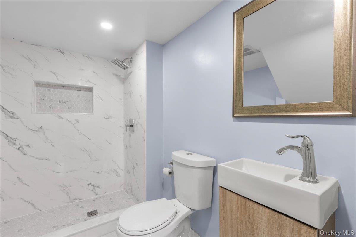 111 Spier Road Scarsdale, NY 10583 - Photo 26 of 37 a white toilet sitting next to a bathroom sink