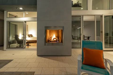 a patio with a table and chairs and potted plants