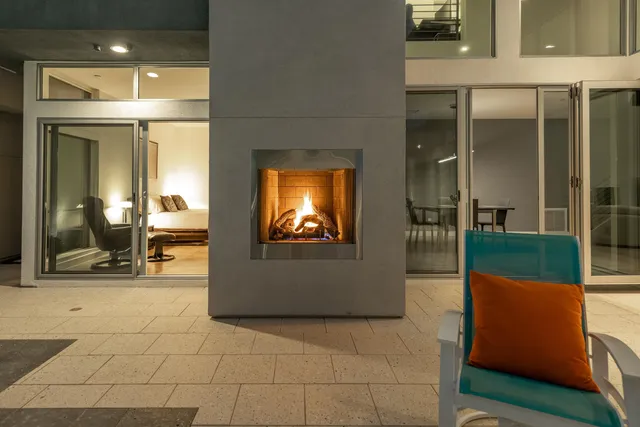 a patio with a table and chairs and potted plants