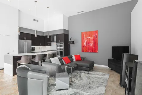 a living room with stainless steel appliances kitchen island granite countertop a table and chairs in it
